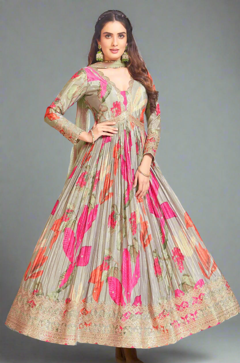 A model wearing a traditional Indian anarkali suit in gray with floral print and embroidery, paired with a matching scarf.