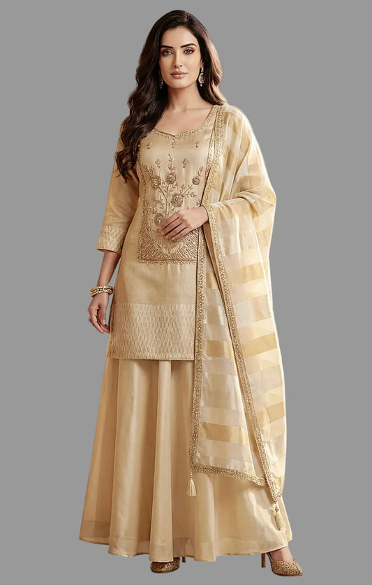 Woman wearing a traditional beige outfit with intricate designs in a decorative setting.